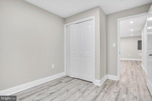 unfurnished bedroom with light hardwood / wood-style flooring and a closet