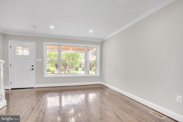 interior space with crown molding and light hardwood / wood-style flooring