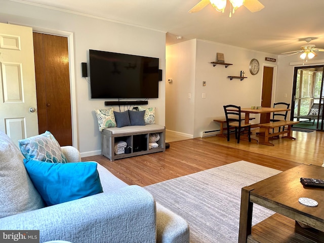 living room with hardwood / wood-style flooring, ceiling fan, and ornamental molding