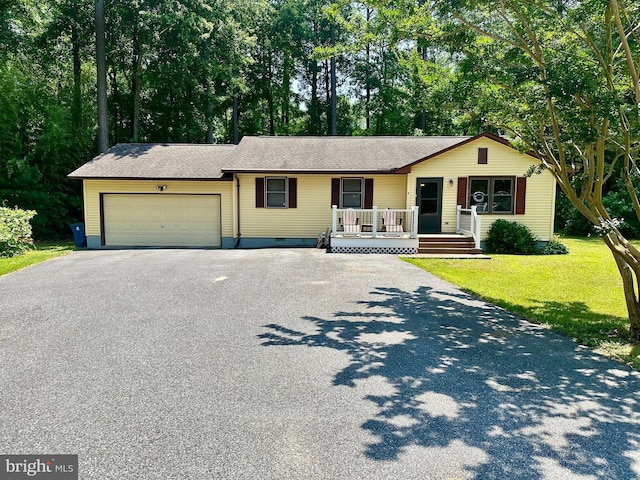 ranch-style home with a front lawn, a porch, and a garage