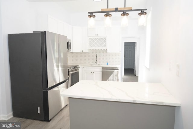 kitchen with sink, light hardwood / wood-style flooring, light stone countertops, white cabinetry, and stainless steel appliances