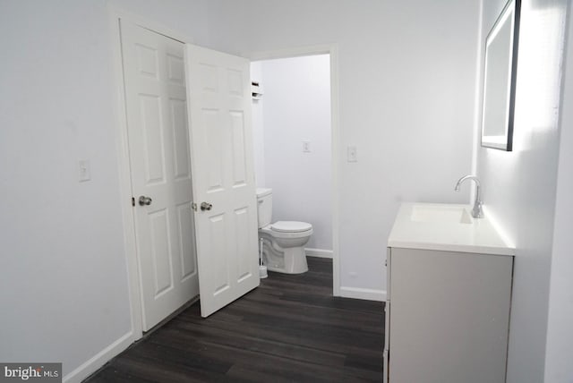 bathroom featuring vanity, hardwood / wood-style flooring, and toilet