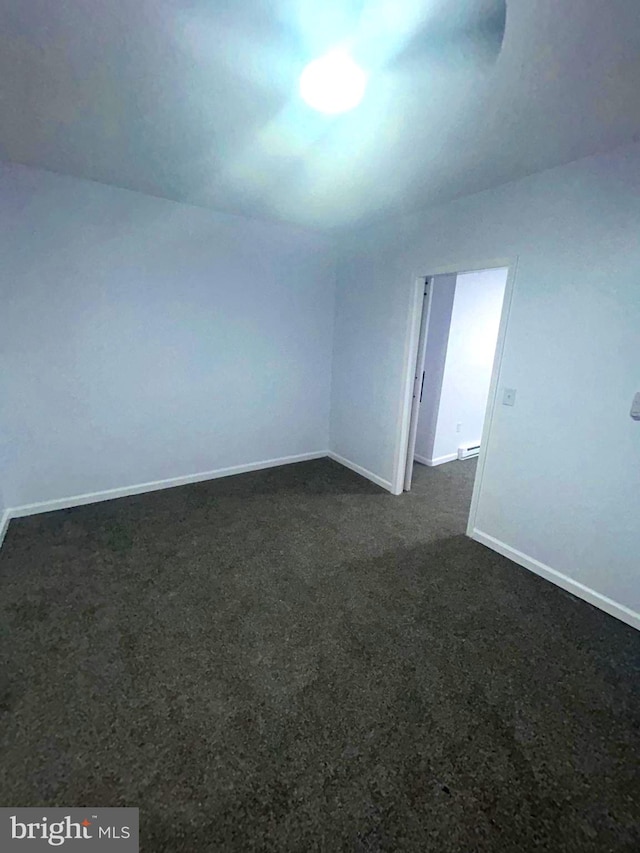 empty room featuring dark carpet