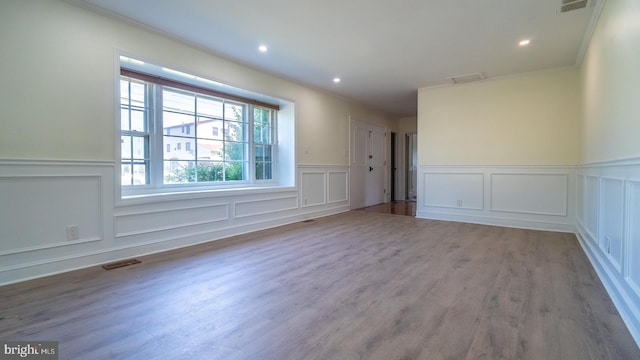 empty room with wood-type flooring and ornamental molding