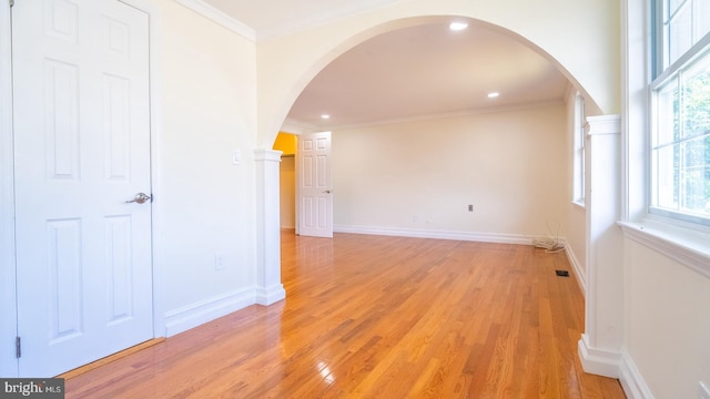 unfurnished room with light wood-type flooring and ornamental molding