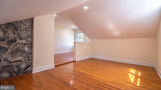 additional living space featuring wood-type flooring and lofted ceiling