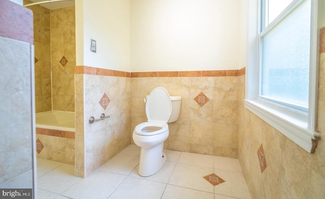 bathroom with tile patterned flooring, tile walls, and toilet