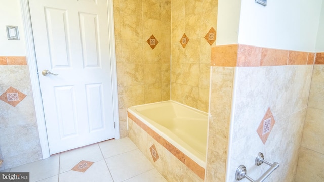 bathroom with tile patterned flooring, a relaxing tiled tub, and tile walls