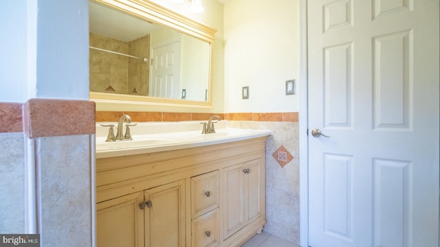 bathroom featuring vanity and tile walls