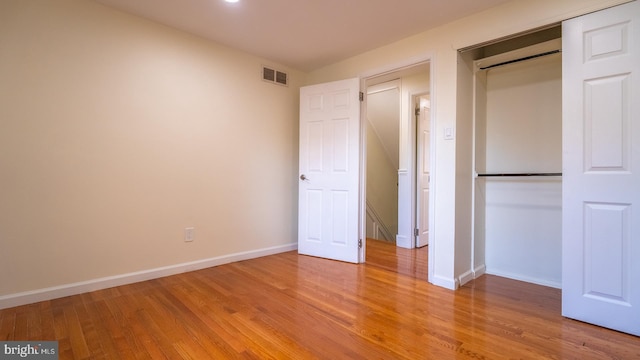 unfurnished bedroom with light hardwood / wood-style flooring and a closet