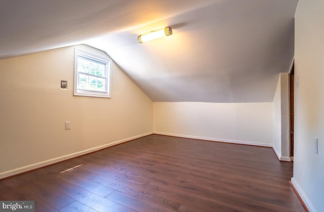 additional living space featuring dark hardwood / wood-style floors and vaulted ceiling