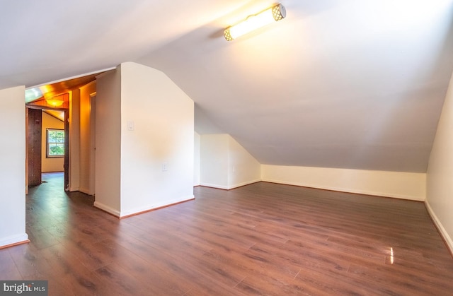 additional living space with dark hardwood / wood-style flooring and lofted ceiling