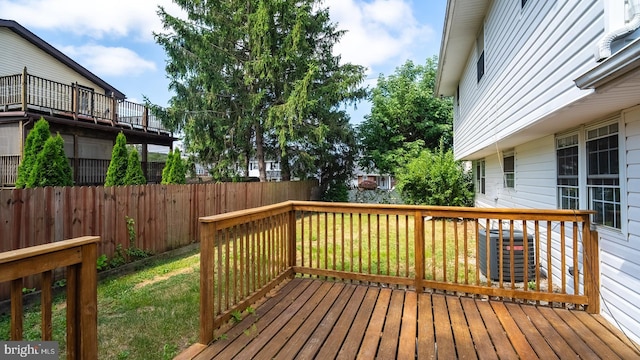 wooden deck featuring a yard and central air condition unit