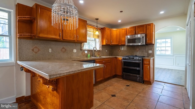 kitchen featuring a breakfast bar, sink, hanging light fixtures, appliances with stainless steel finishes, and kitchen peninsula