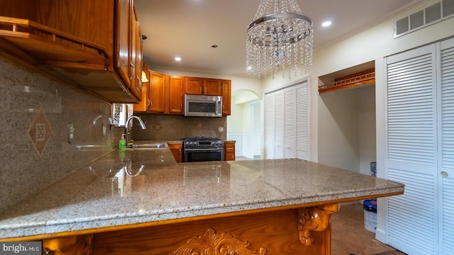 kitchen featuring kitchen peninsula, tasteful backsplash, a breakfast bar, stainless steel appliances, and decorative light fixtures