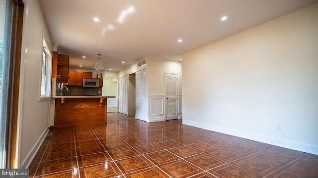 kitchen with backsplash, kitchen peninsula, a breakfast bar, and sink