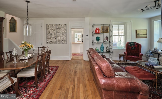 living room featuring light wood-type flooring and a baseboard heating unit