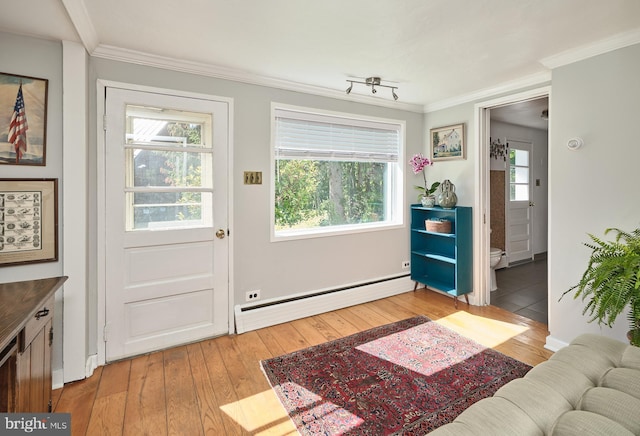 doorway to outside featuring light hardwood / wood-style floors, ornamental molding, and a baseboard heating unit