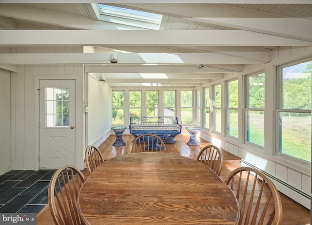 sunroom featuring a baseboard radiator and vaulted ceiling with skylight