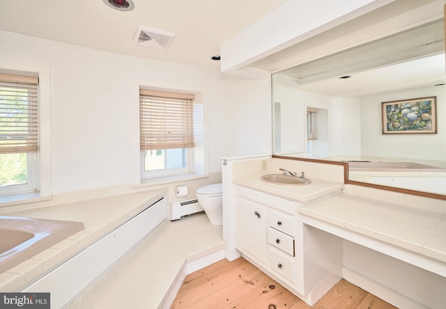 bathroom featuring plenty of natural light, a baseboard radiator, and hardwood / wood-style flooring