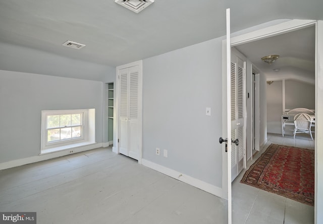 unfurnished room with lofted ceiling