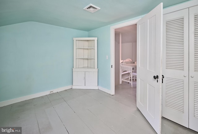 unfurnished bedroom with a closet and lofted ceiling