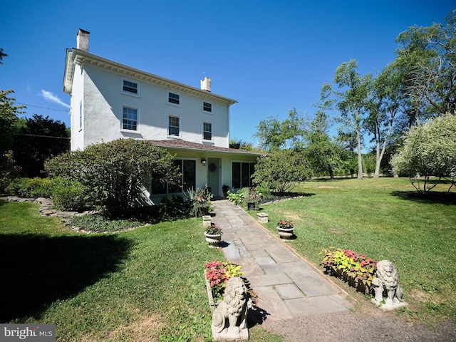 back of house with a lawn