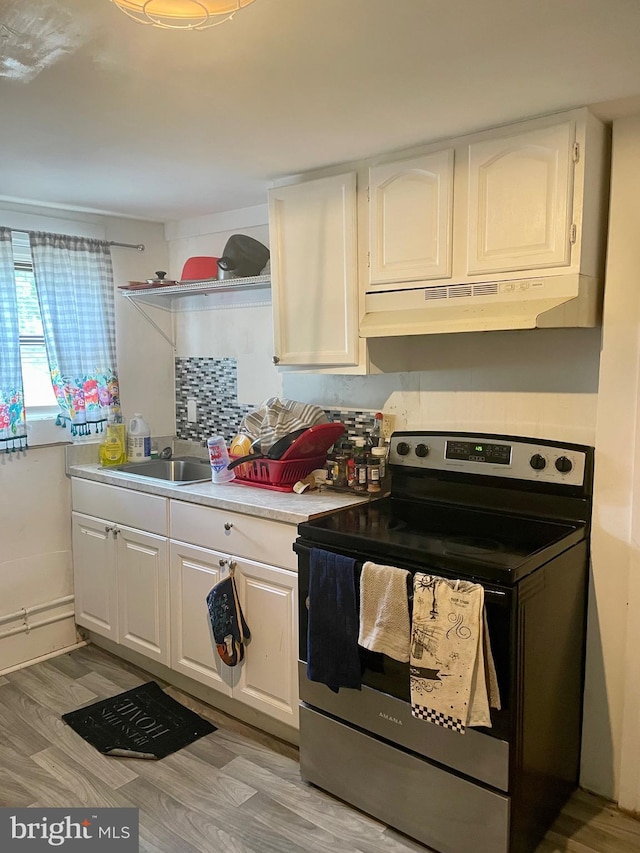 kitchen featuring white cabinetry, light hardwood / wood-style flooring, stainless steel range with electric cooktop, and sink