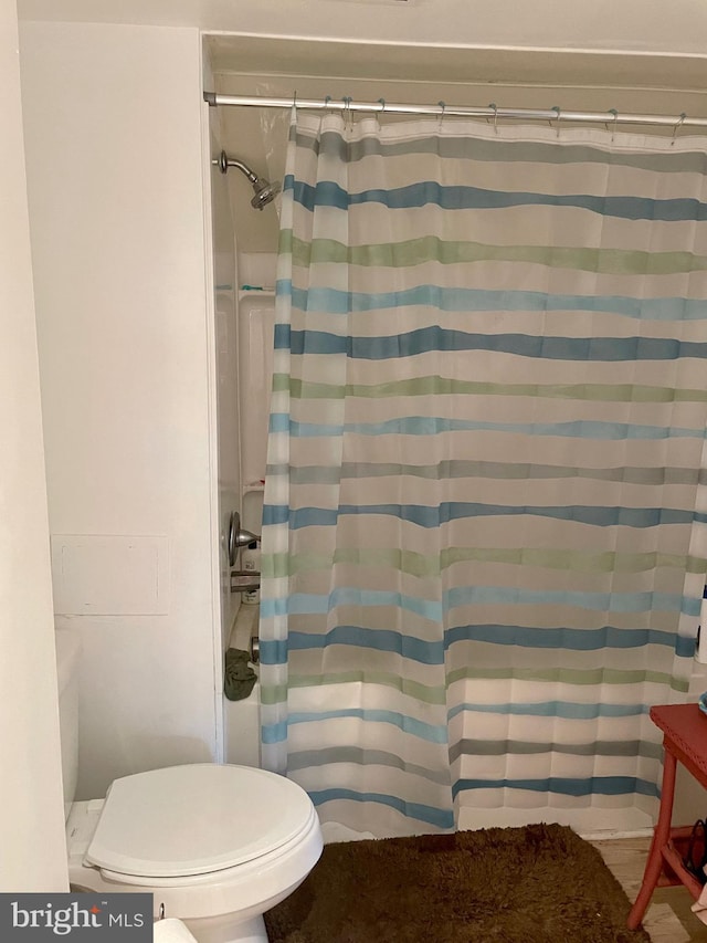 bathroom featuring toilet and a shower with shower curtain