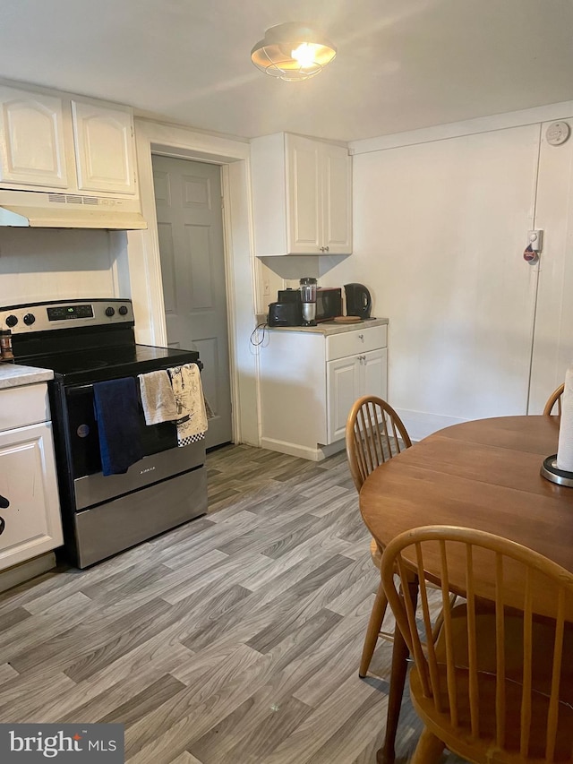 kitchen with white cabinetry, light hardwood / wood-style flooring, and stainless steel electric range