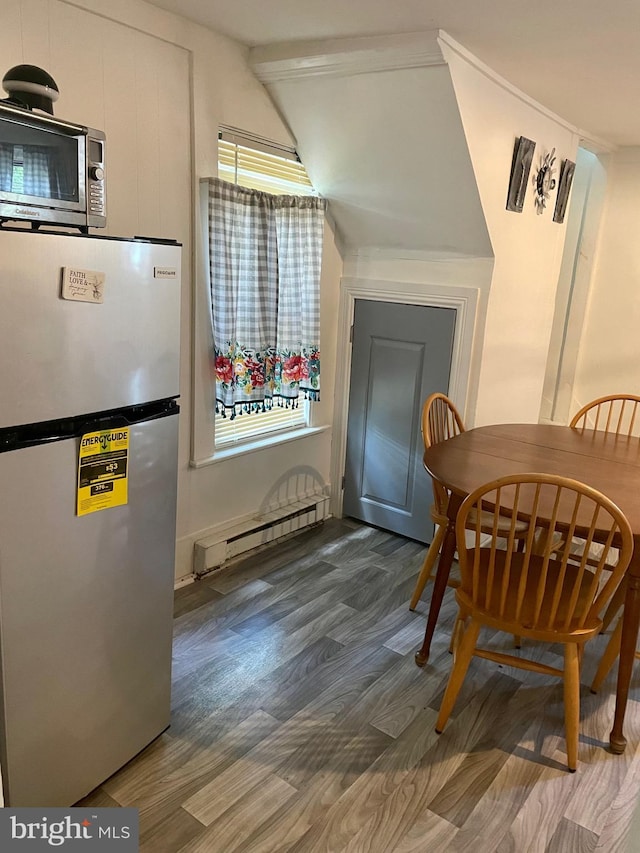 dining room featuring dark wood-type flooring and a baseboard heating unit