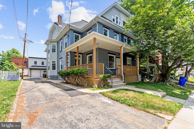 view of front of house with covered porch, an outdoor structure, and a garage