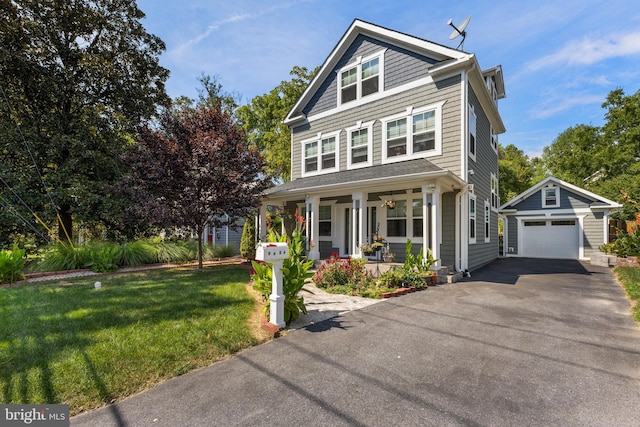 view of front of property featuring a front yard, covered porch, an outdoor structure, and a garage