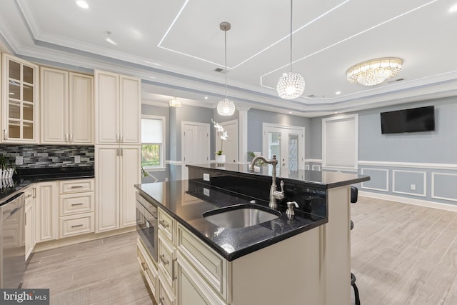 kitchen with a kitchen breakfast bar, stainless steel appliances, decorative light fixtures, and a kitchen island with sink