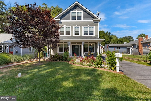 view of front of house featuring a front lawn, a porch, fence, and aphalt driveway