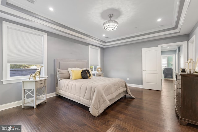 bedroom with dark hardwood / wood-style floors, a raised ceiling, and ornamental molding