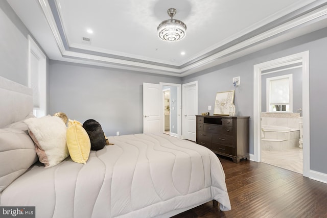 bedroom with a tray ceiling, ensuite bathroom, crown molding, and dark hardwood / wood-style floors