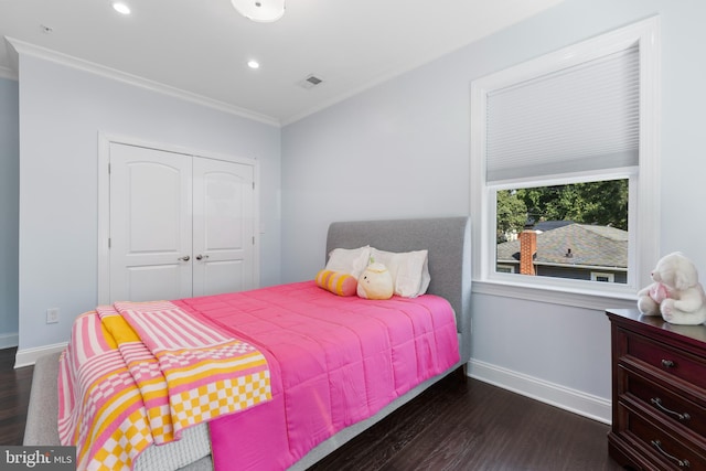 bedroom featuring ornamental molding, dark wood-type flooring, and a closet