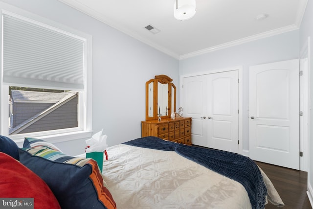 bedroom featuring crown molding, a closet, and dark wood-type flooring