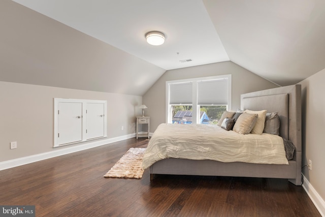 bedroom featuring dark hardwood / wood-style flooring and lofted ceiling