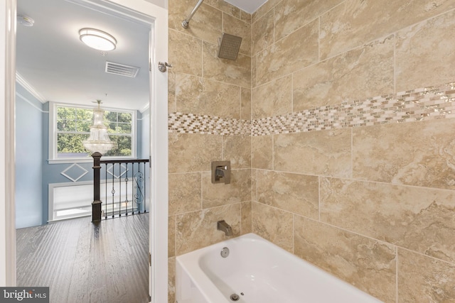 bathroom with crown molding, tiled shower / bath combo, and hardwood / wood-style flooring