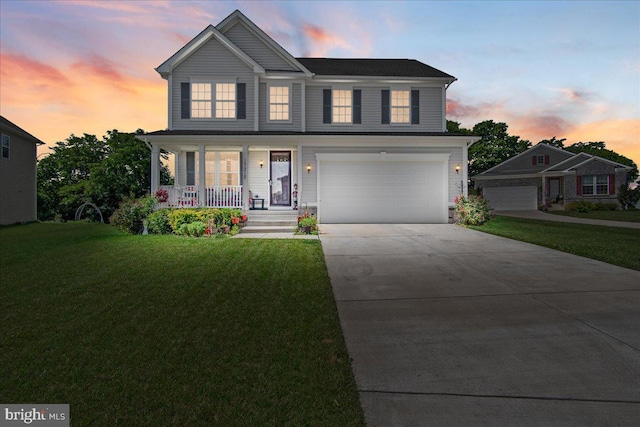 view of front facade with covered porch, a garage, and a yard