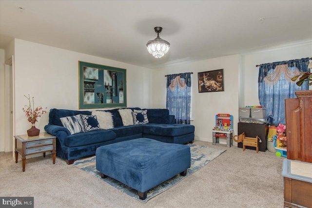 carpeted living room with a chandelier