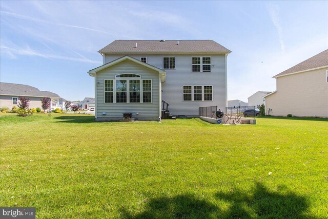 rear view of house with a yard and central air condition unit