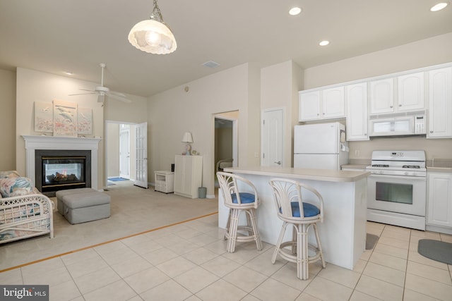 kitchen with light countertops, white appliances, hanging light fixtures, and white cabinets