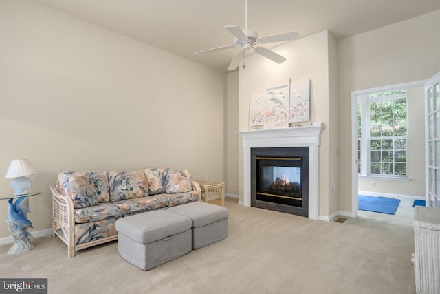 living area featuring light carpet, a multi sided fireplace, a ceiling fan, baseboards, and vaulted ceiling