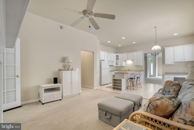 living room featuring light carpet, baseboards, a ceiling fan, and recessed lighting