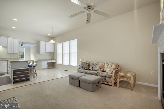 living room featuring light tile patterned floors, recessed lighting, baseboards, and light colored carpet