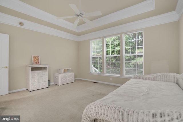 bedroom featuring ornamental molding, a tray ceiling, and multiple windows