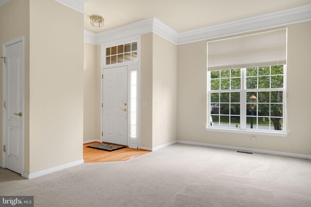 entryway featuring light carpet and crown molding